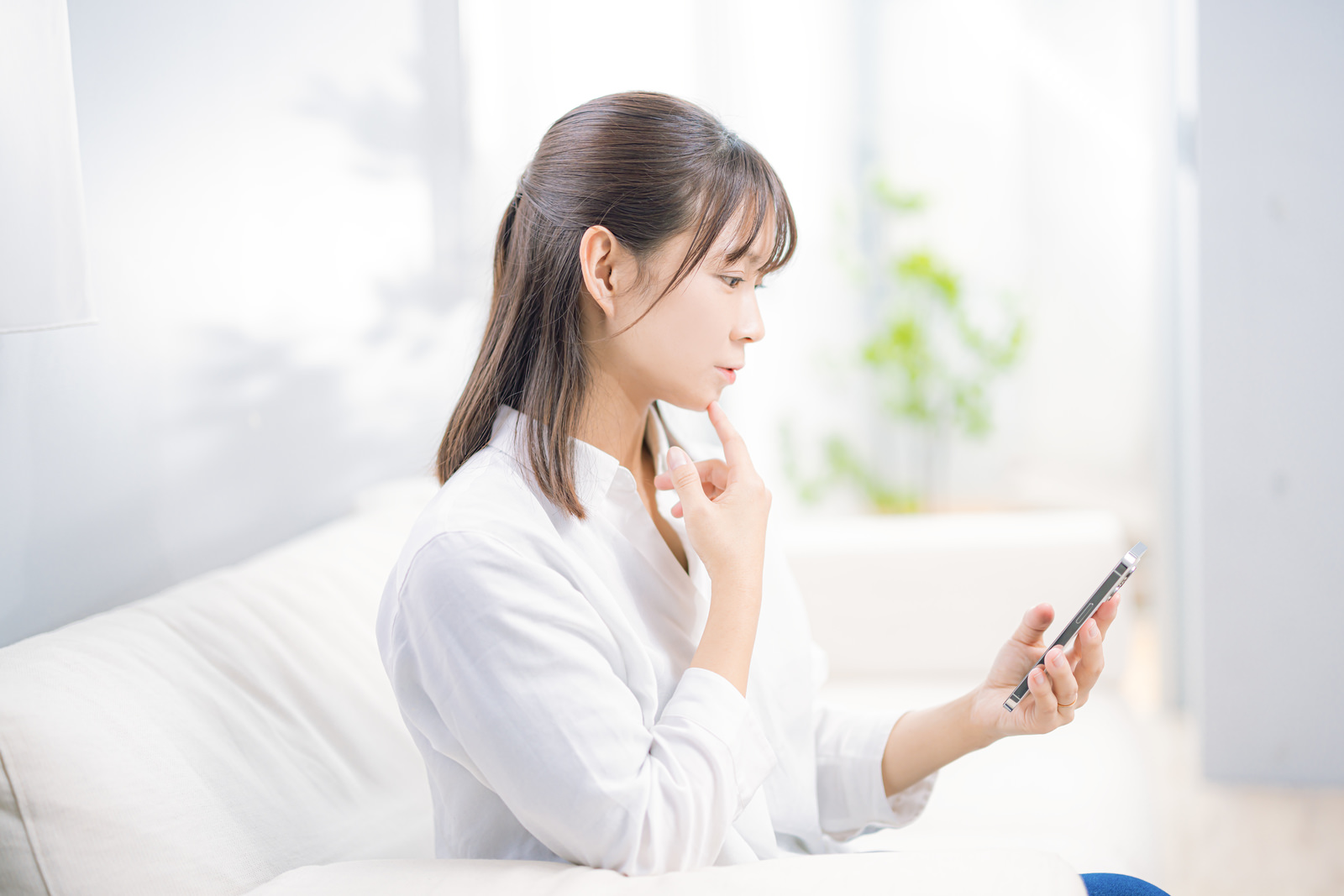 スマートフォンを見ながら情報を検索する女性